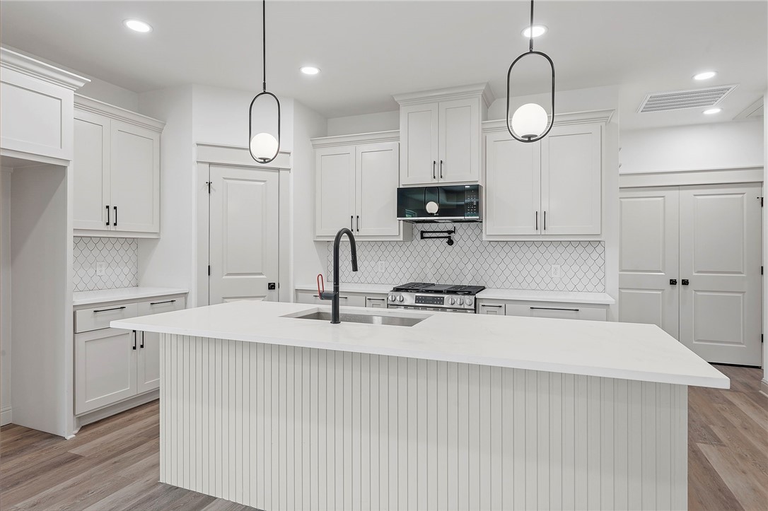 505 Legion Court Bryan, TX 77803 - Photo 6 of 21 a kitchen with stainless steel appliances granite countertop a sink a stove and a refrigerator