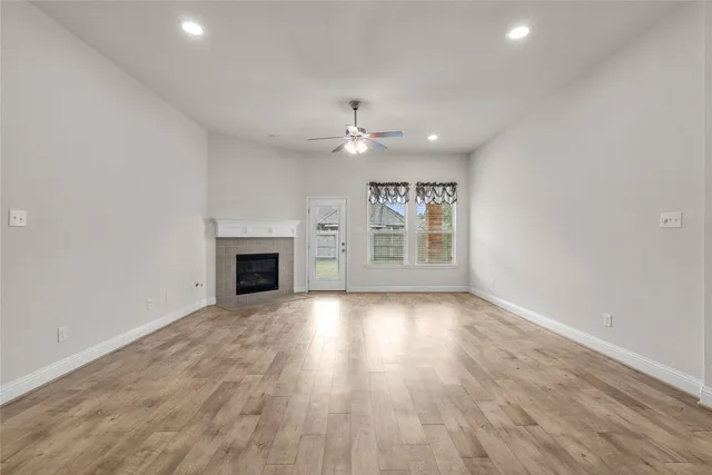 an empty room with wooden floor and fireplace
