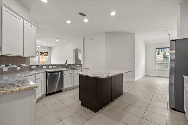 a kitchen with stainless steel appliances granite countertop a refrigerator and a stove top oven