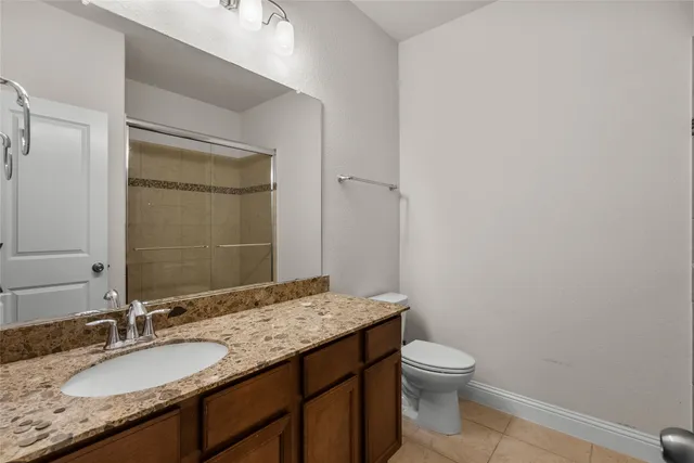 a bathroom with a granite countertop shower and a sink