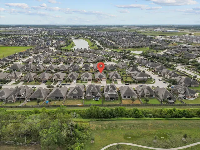 a view of a hallway with wooden floor and a bathroom
