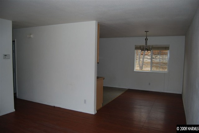 1095 Akard Drive Reno, NV 89503 - Photo 4 of 9 an empty room with wooden floor cabinet and windows