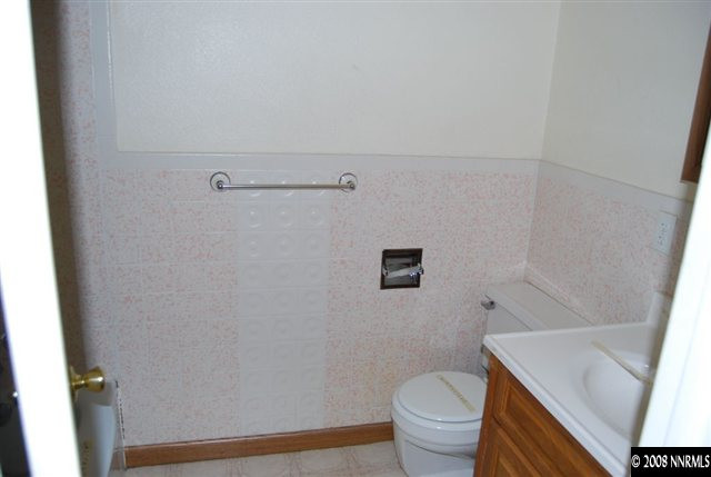 1095 Akard Drive Reno, NV 89503 - Photo 5 of 9 a white toilet sitting next to a bathroom sink and vanity