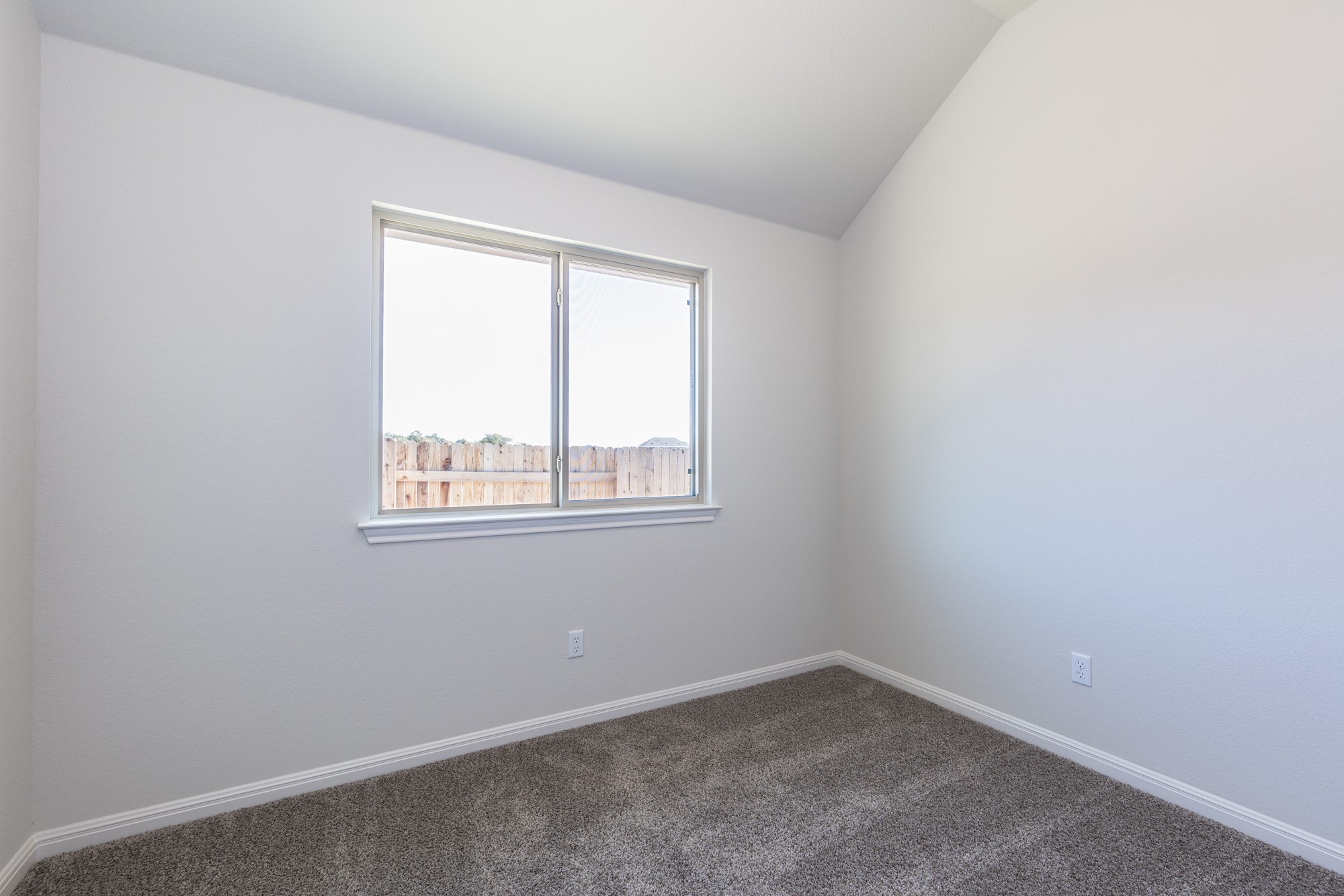 2725 Hopi Path Leander, TX 78641 - Photo 9 of 30 A well-lit room with plush carpeting and a clear window, offering views of the surrounding fence line.