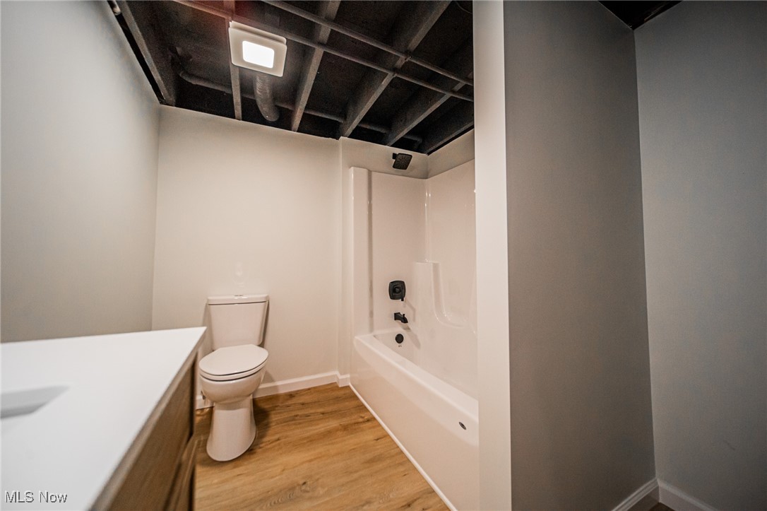 55 Elm Street Rittman, OH 44270 - Photo 29 of 46 Bathroom with toilet, wood finished floors, vanity, washtub / shower combination, and baseboards