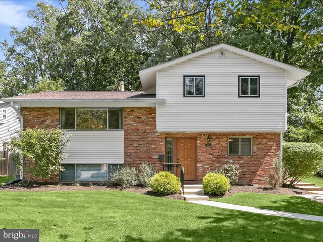 a front view of a house with a garden and plants