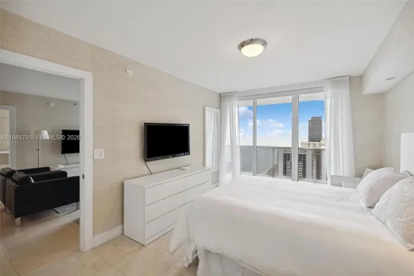 a bedroom with a bed and a flat screen tv