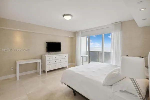 a bedroom with a bed and a flat screen tv