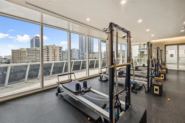 a room with gym equipment and large glass windows