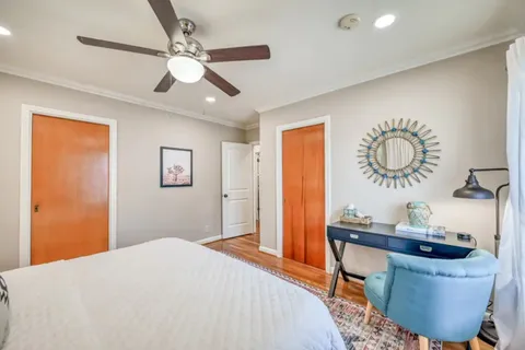 a bedroom with a large bed and a chandelier
