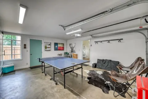 a room with furniture pool table and windows