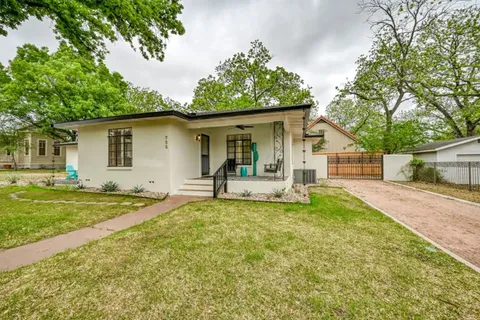 a view of a house with a yard and sitting area