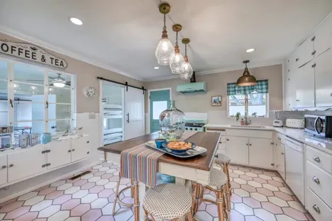 a kitchen with granite countertop a table and chairs in it