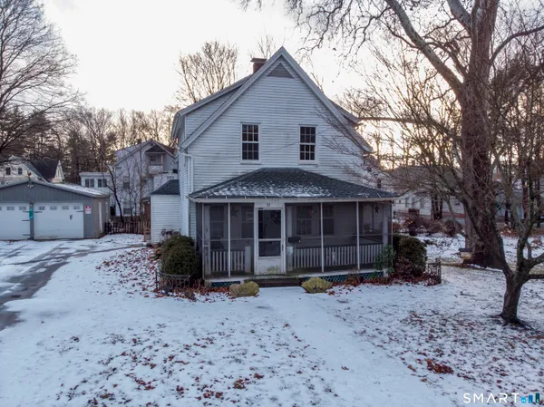 a view of a house with a yard and a large tree