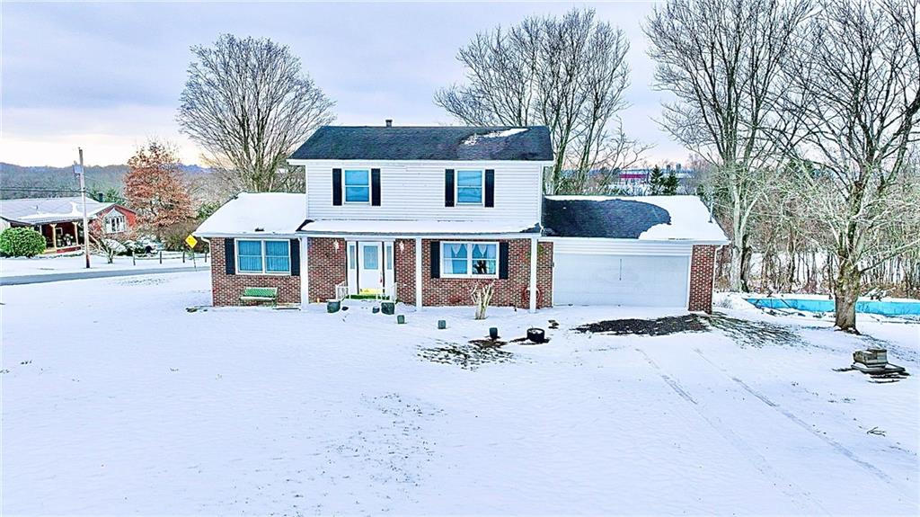 a front view of a house with a yard covered in snow
