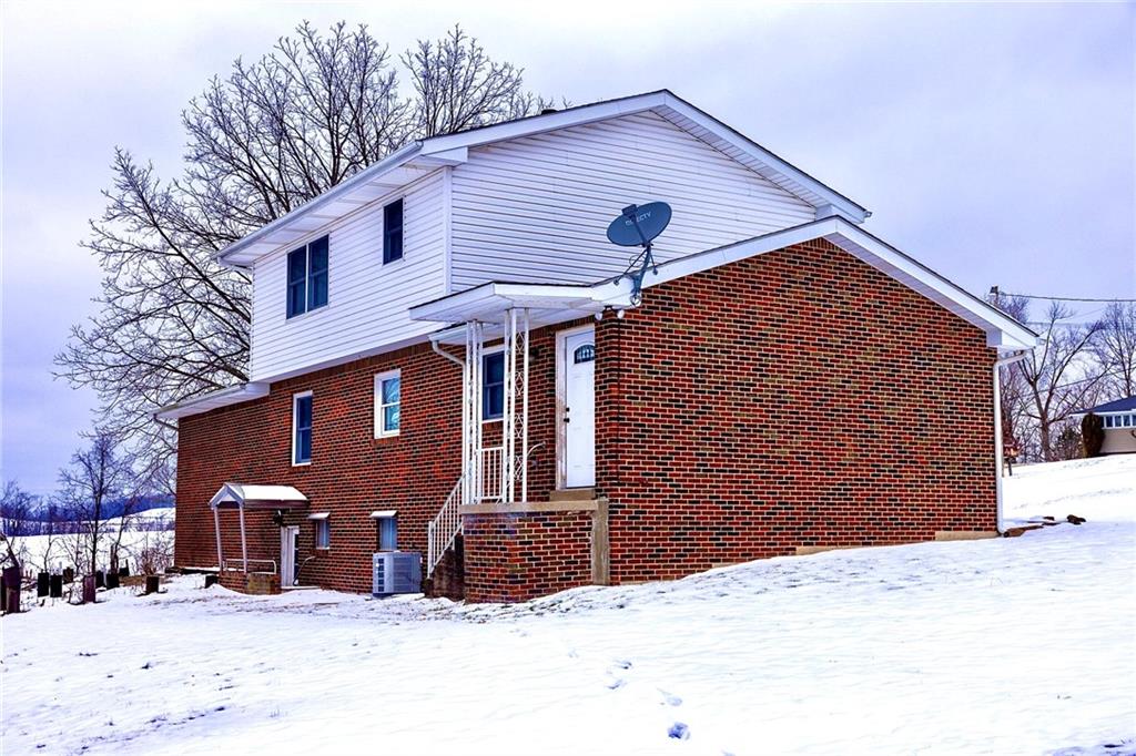 1142 Apples Mill Road West Newton, PA 15089 - Photo 28 of 32 a front view of a house with a yard covered in snow
