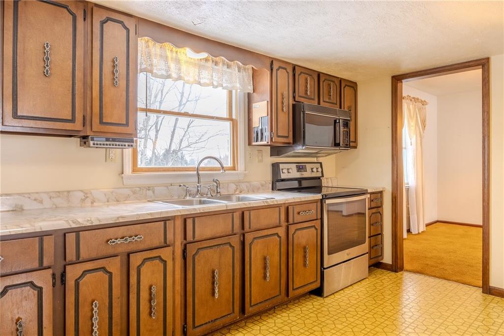 1142 Apples Mill Road West Newton, PA 15089 - Photo 10 of 32 a kitchen with stainless steel appliances granite countertop a stove a sink and a microwave