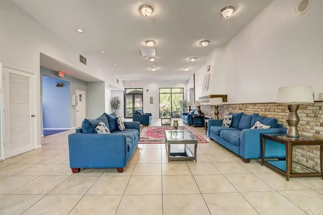 a living room with couches and kitchen view with wooden floor