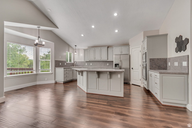 2154 Wasatch Boulevard Sandy, UT 84092 - Photo 22 of 55 Kitchen with a kitchen island, a breakfast bar, hanging light fixtures, stainless steel appliances, and backsplash