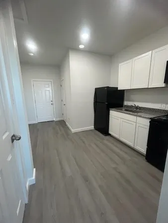 a view of a kitchen with a sink and dishwasher a refrigerator with wooden floor