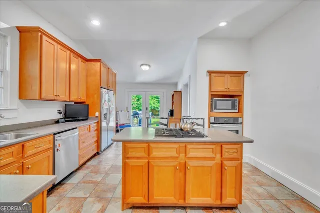 a large kitchen with kitchen island granite countertop a sink and a window