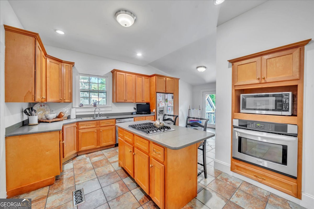 712 Stonewall Street Dublin, GA 31021 - Photo 13 of 65 a kitchen with stainless steel appliances granite countertop a sink stove and refrigerator