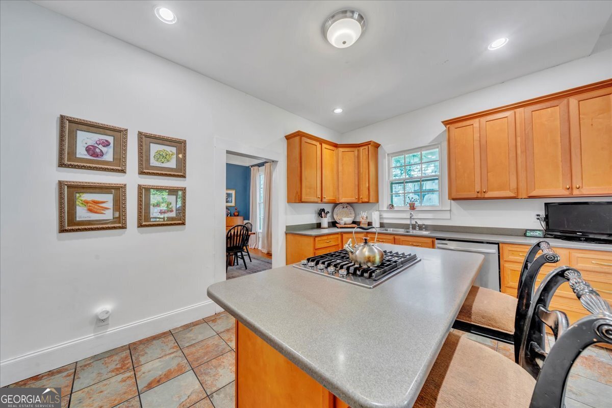 712 Stonewall Street Dublin, GA 31021 - Photo 14 of 65 a kitchen with stainless steel appliances granite countertop a refrigerator a stove top oven a sink a dining table and chairs with wooden floor