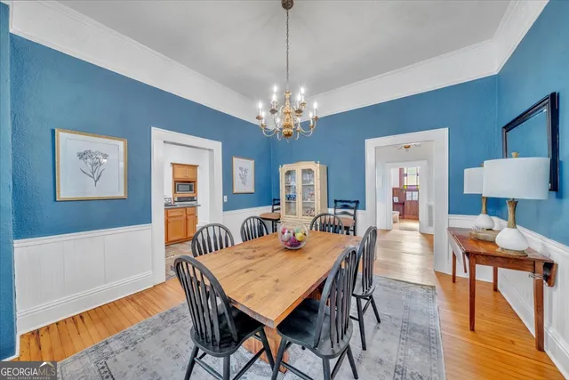 a dining room with furniture a chandelier and wooden floor