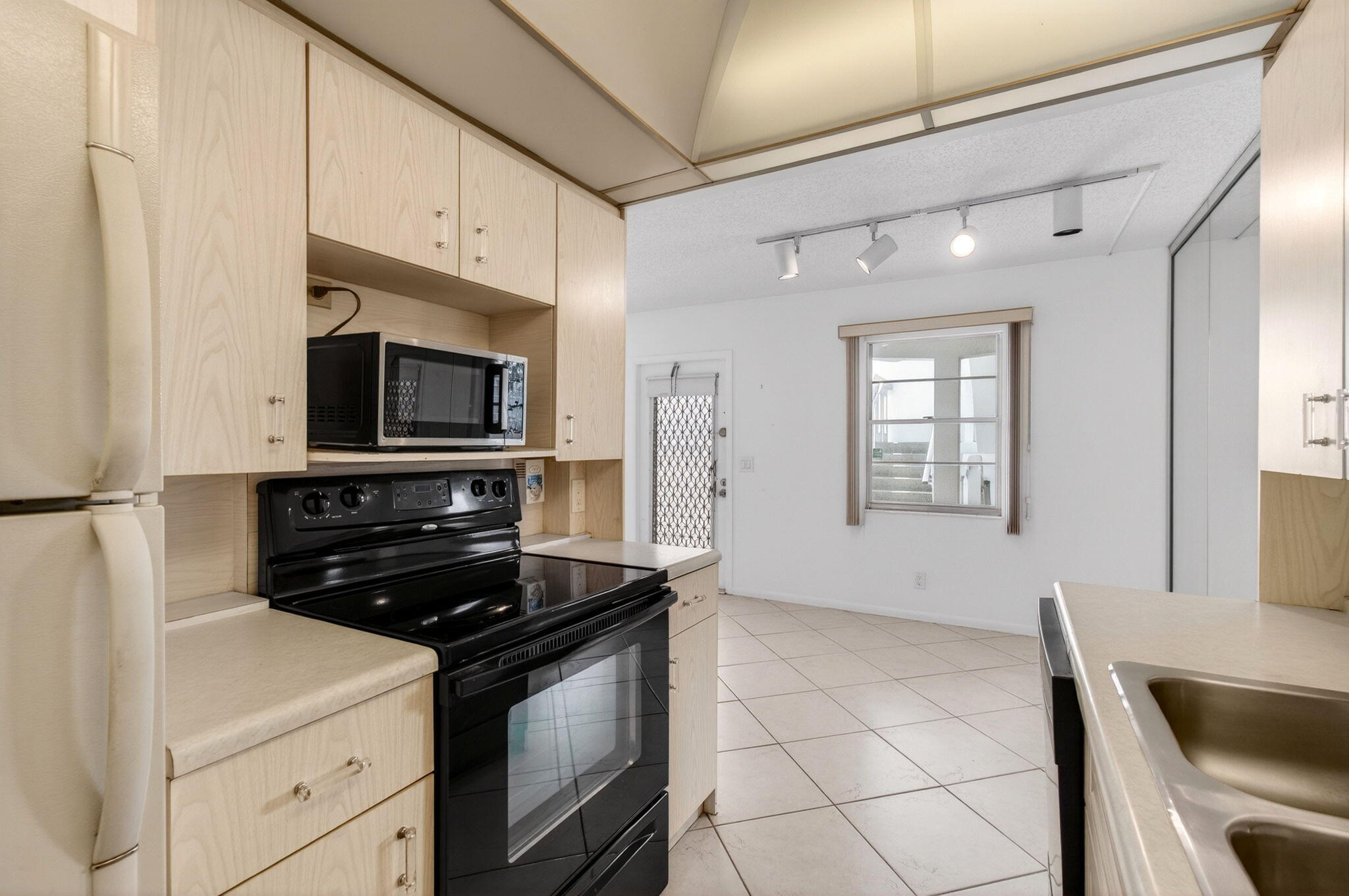 2027 Exeter Boca Raton, FL 33434 - Photo 26 of 100 a kitchen with stainless steel appliances a stove a microwave and white cabinets