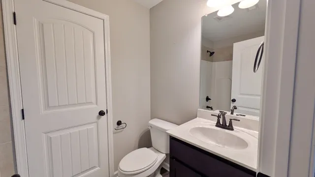 a bathroom with a sink vanity mirror and toilet