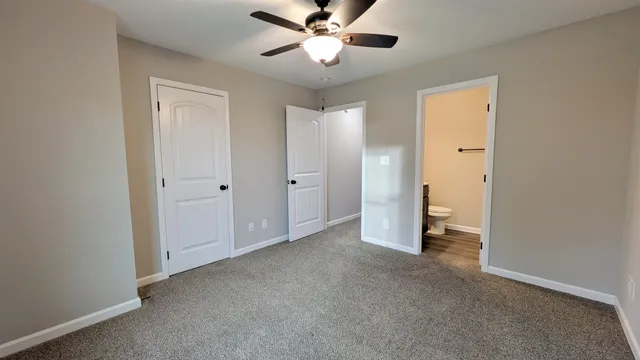 a view of a room with a ceiling fan and a bathroom