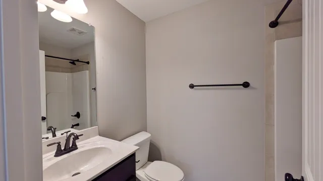 a bathroom with a sink toilet and mirror