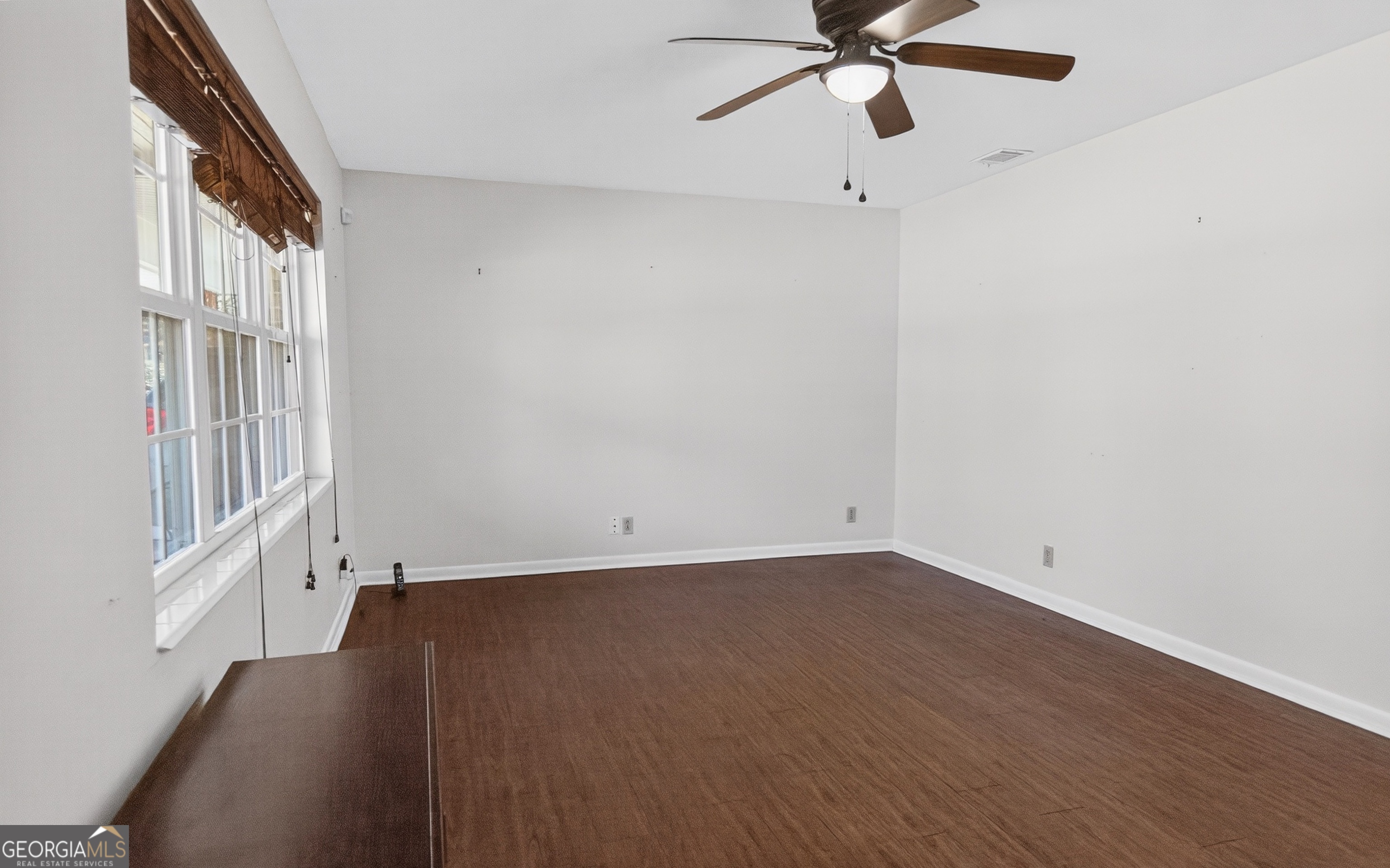 104 Azalea Lane Reidsville, GA 30453 - Photo 25 of 50 an empty room with wooden floor and windows