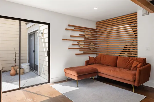 a living room with furniture a flat screen tv and a floor to ceiling window