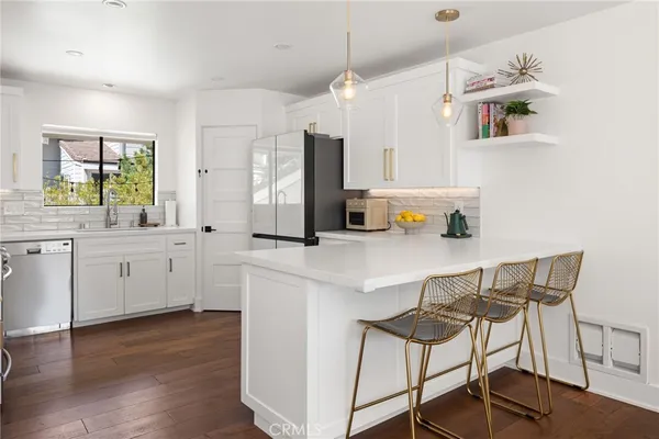a kitchen with cabinets stainless steel appliances and wooden floor