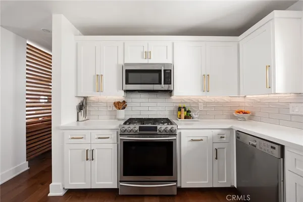 a kitchen with white cabinets and white appliances