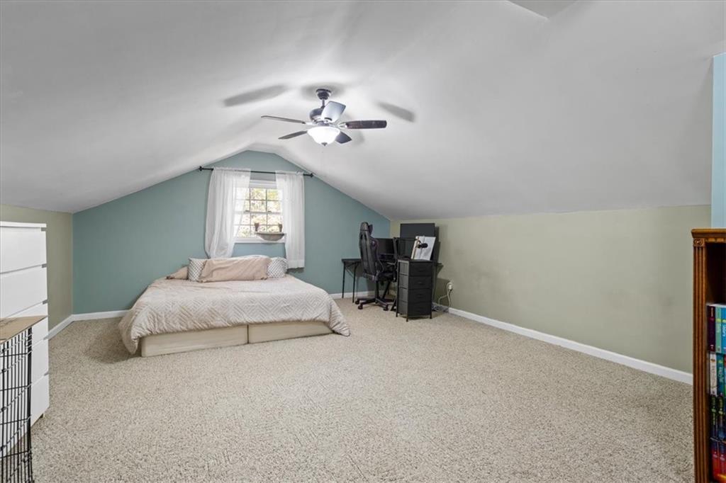 564 Eskew Road McDonough, GA 30252 - Photo 33 of 54 a spacious bedroom with a bed and a chandelier