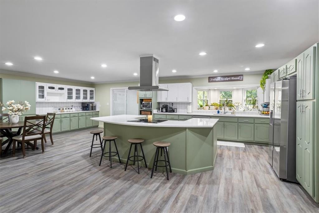 564 Eskew Road McDonough, GA 30252 - Photo 4 of 54 a kitchen with a dining table chairs wooden floor appliances and cabinets