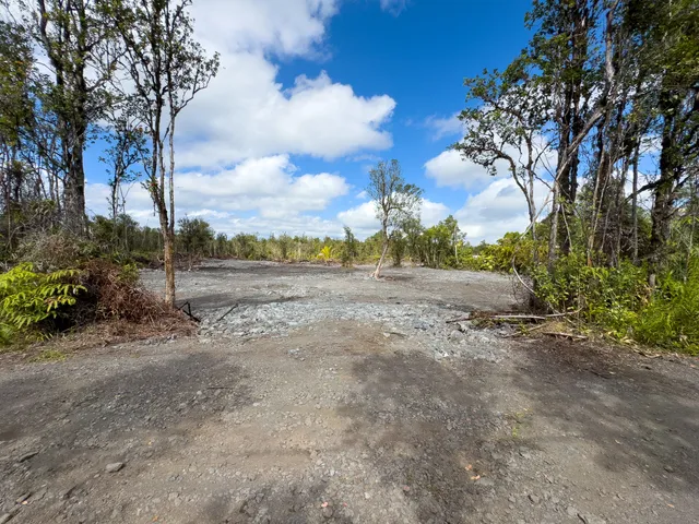 a view of a dirt road with a building in the background