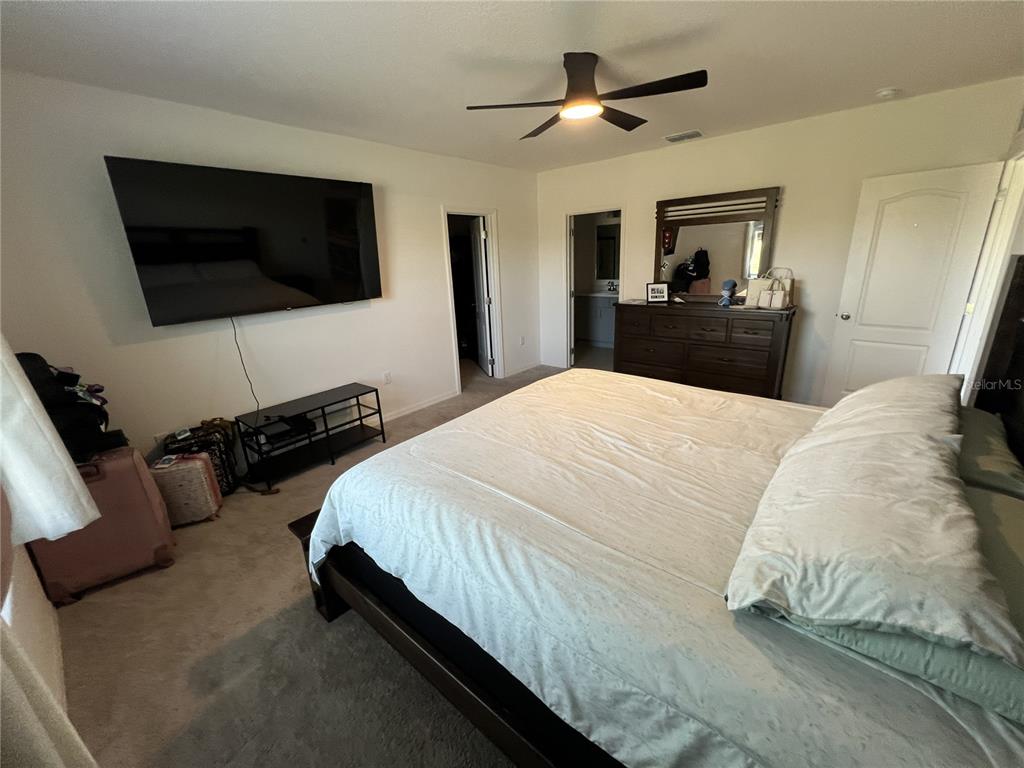 1106 Althea Drive Indian Lake Estates, FL 33843 - Photo 5 of 56 a spacious bedroom with a bed and a flat screen tv