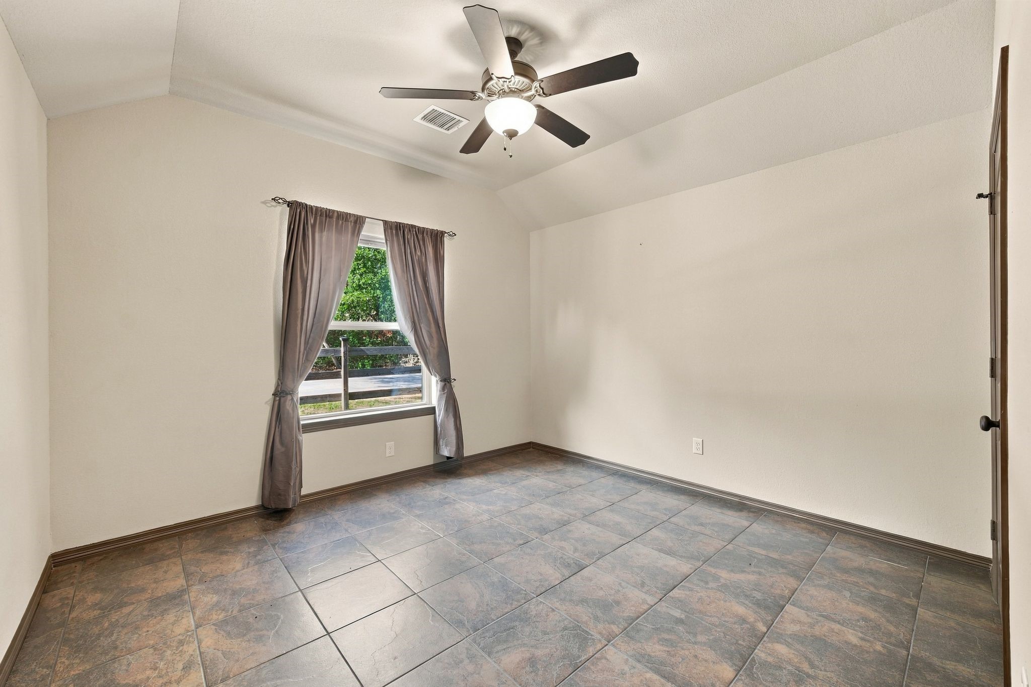 7049 Pine Shadows Road Cleveland, TX 77328 - Photo 27 of 49 Spacious room with elegant tile flooring, a ceiling fan, and a large window bringing in natural light.
