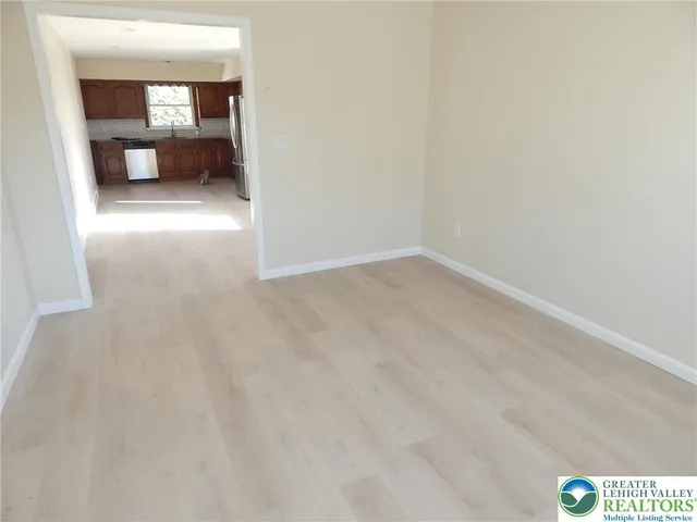 a view of a hallway with wooden floor and a bathroom