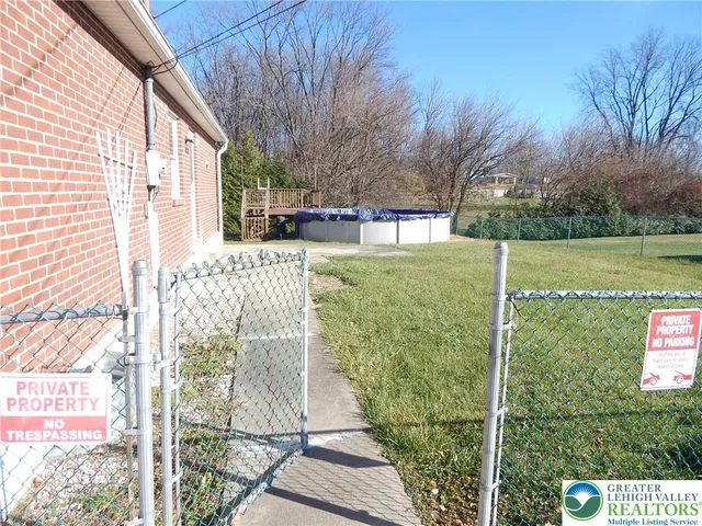 a backyard of a house with large trees and plants