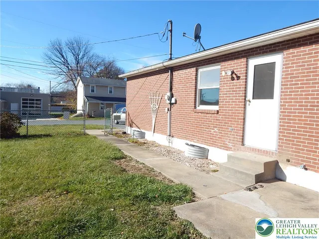 a view of a house with a yard and sitting area