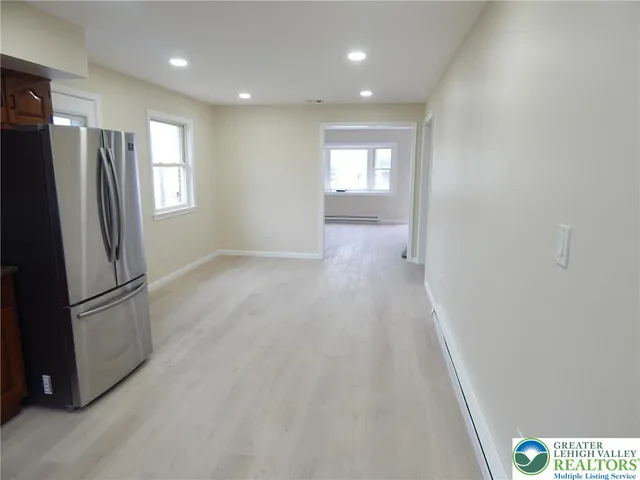 a view of a kitchen with a refrigerator wooden floor and window