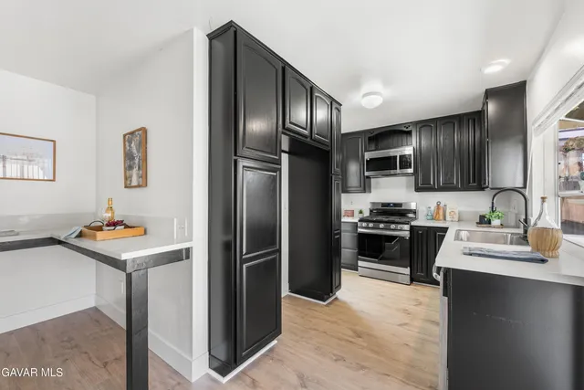 a kitchen with granite countertop stainless steel appliances and wooden cabinets