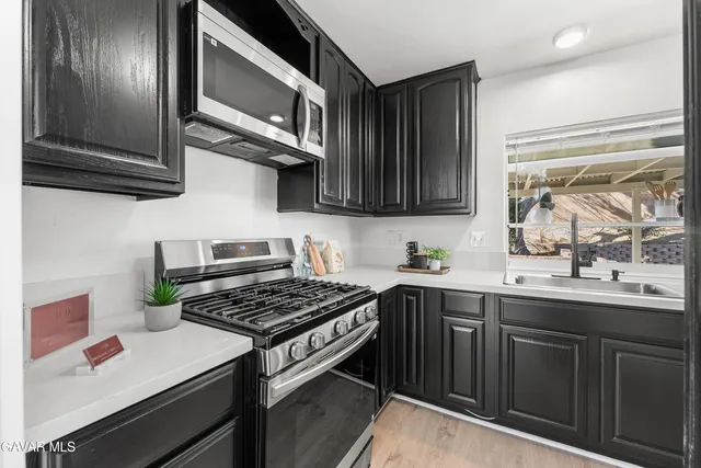 a kitchen with stainless steel appliances a sink stove and cabinets