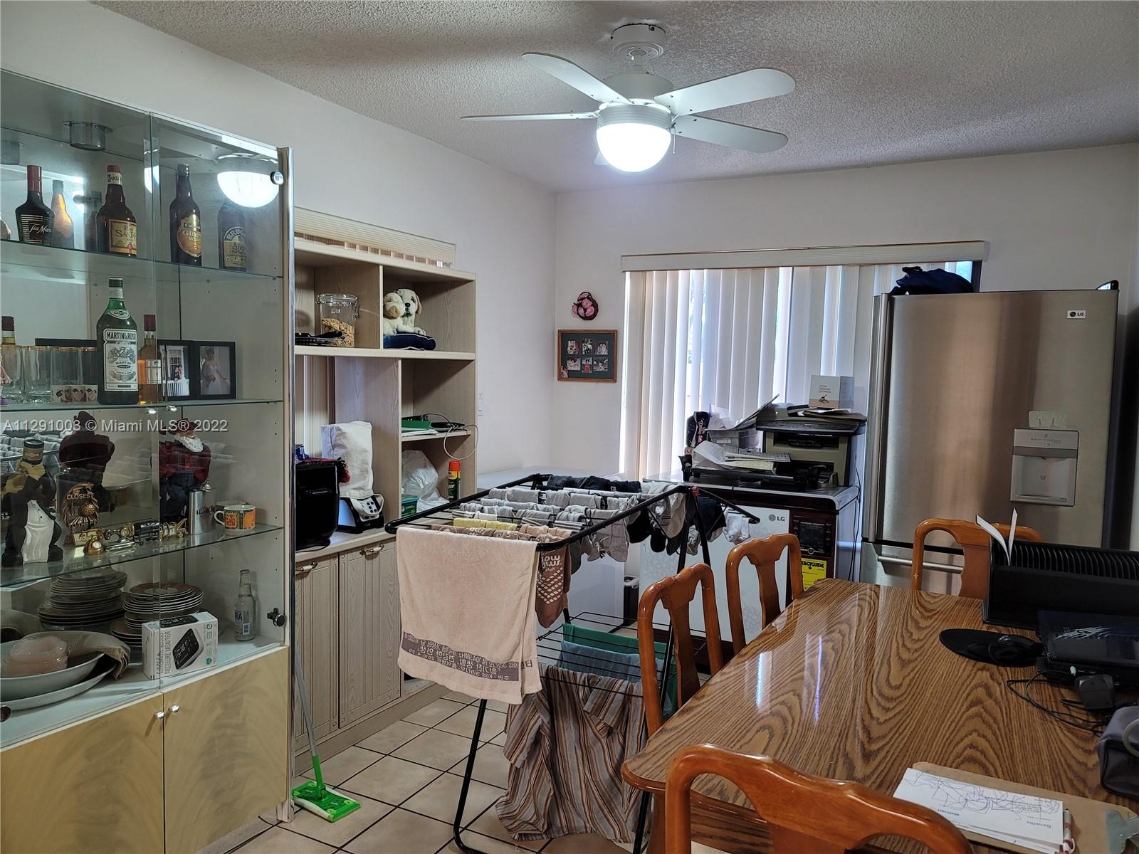 3931 Southwest 84th Terrace Davie, FL 33328 - Photo 12 of 15 a kitchen with stainless steel appliances a stove a refrigerator a sink a dining table and chairs with wooden floor