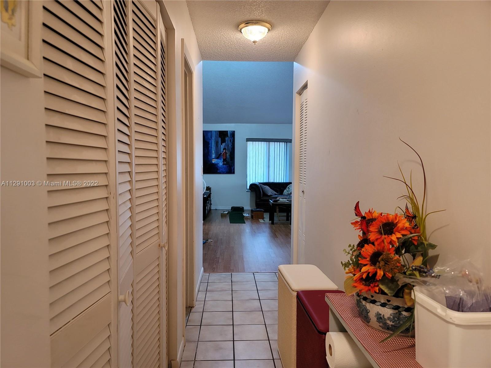 3931 Southwest 84th Terrace Davie, FL 33328 - Photo 14 of 15 a hallway with a dining table and chairs