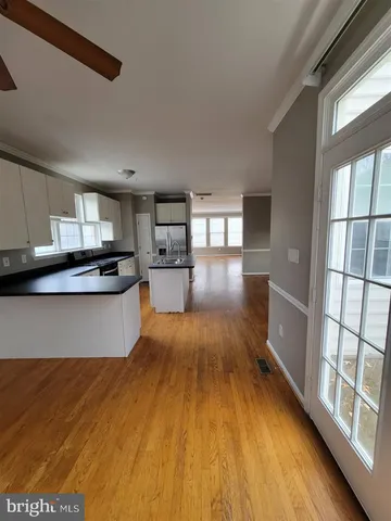 a large kitchen with lots of counter top space and wooden floor